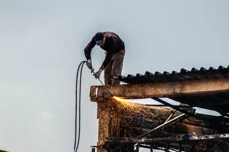 A roofer applying a torch-on felt roof.