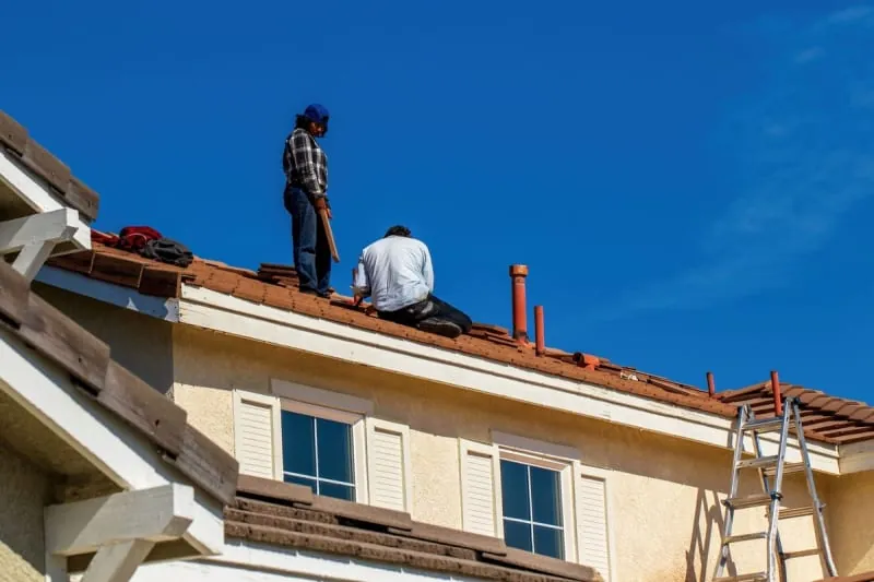 Close-up of a roofer fixing roof tiles.