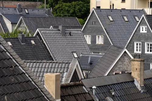 A grey slate tiled roof against a blue sky.